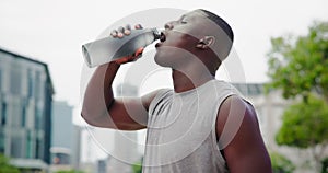 Sweat, drinking water and fitness of black man with exercise, training and workout with break outdoor. Tired, bottle and