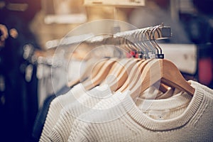 Sweaters on hangers. Shopping in store. Clothes on hangers in shop for sale