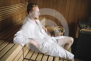 Sweating attractive man laying in a sauna