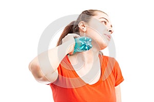 Sweating attractive young woman cooling with bottle of water