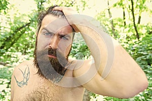 Sweating and body odor care. Perspiring hipster touching his wet hair. Bearded man experiencing sweating on hot day