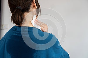 sweating woman with wet cloth because of hot weather in summer time, menopause symptom concept photo
