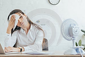 sweaty businesswoman working in office with electric