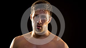 Sweaty male boxer hardly breathing after exhausted training, professional sport photo