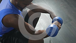 Sweaty sportsman lifting dumbbell, workout in gym, strength of will, disciplined