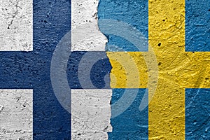 Sweden and Finland - Cracked concrete wall painted with a Swedish flag on the left and a Finnish flag on the right stock photo