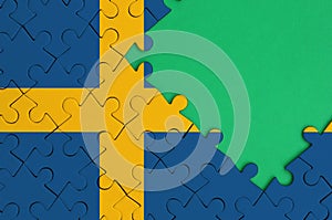 Sweden flag is depicted on a completed jigsaw puzzle with free green copy space on the right side