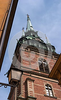Sweden, Stockholm, on an old street in Gamlastan. The ancient part of the city. The bell tower of the German church photo
