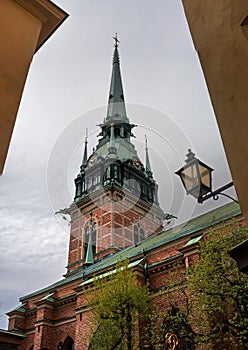 Sweden, Stockholm, on an old street in Gamlastan. The ancient part of the city. The bell tower of the German church photo