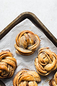 Swedish cinnamon buns on a parchment lined baking sheet