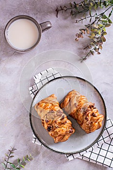 Swedish fika time with fresh cinnamon buns and a cup of latte on the table top and vertical view