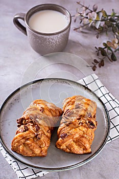 Swedish fika time with fresh cinnamon buns and a cup of latte on the table vertical view