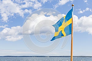 Swedish flag on boat against cloudy sky windy