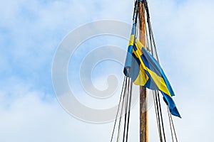 Swedish flag on sailing boat mast on windy summer day in Halmstad