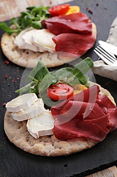 Swedish flatbread hallakaka with ham, cheese, and vegetables