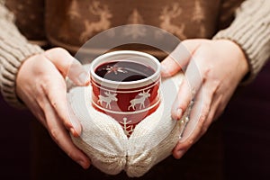 Swedish glogg or mulled wine in knitted gloves. photo