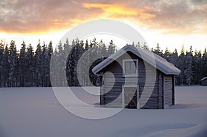 Swedish hut in winter at sundown, Sweden