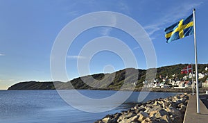 Swedish and Norwegian flags hoisted on mats on the coast of a village