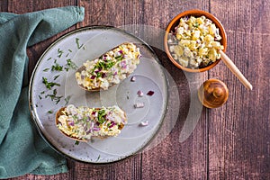 Swedish salad with anchovies, potatoes and egg on rye bread on a plate top view