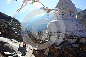 Swedish tourist next to white buddhist stupa on the Everest trek in Himalayas mountains, Nepal