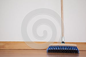 Sweeping broom with wooden handle on floor