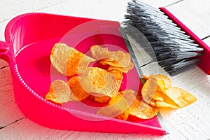 Sweeping junk food with chips and dustpan concept of health detox diet