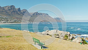 Sweeping shot of Camps Bay blue flag beach, with views to the twelve apostles mountains, Cape Town, South Africa.