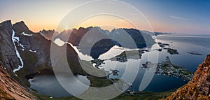 Sweeping super panorama from Reinebringen shows the midnight sun over Lofoten Islands, Norway, illuminating the village of Reine