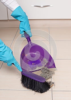 Sweeping tiled floor with brush and dustpan