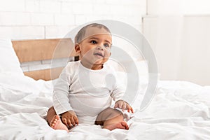 Sweet African American Infant Baby Sitting In Bed Indoor