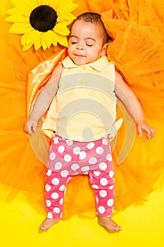 Sweet African baby sleeping on sunflower cloth