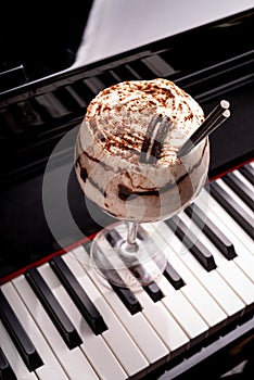 Sweet alcoholic chocolate cocktail garnished with biscuit on a piano keyboard in a night club