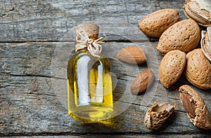 Sweet Almond oil in glass of bottle. Almonds nuts and oil concept