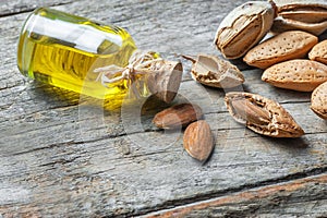 Sweet Almond oil in glass of bottle. Almonds nuts and oil concept