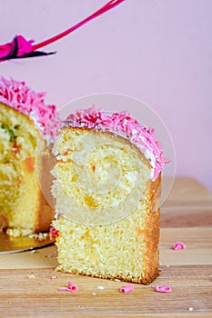 Sweet and appetizing cupcake with pink sprinkling on the table