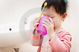 Sweet Asian child little girl brushing her teeth