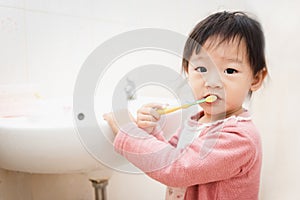 Sweet Asian child little girl brushing her teeth