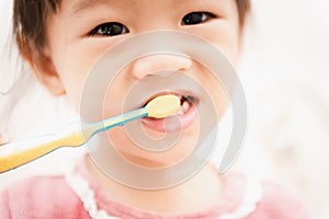 Sweet Asian child little girl brushing her teeth
