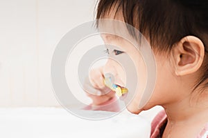 Sweet Asian child little girl brushing her teeth