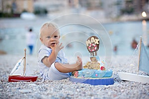 Sweet baby boy, celebrating first birthday with sea theme cake and decoration