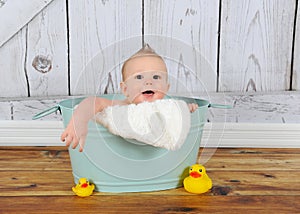Sweet baby boy playing in washtub