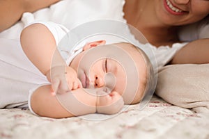 Sweet baby boy sleeping in bed with his mother