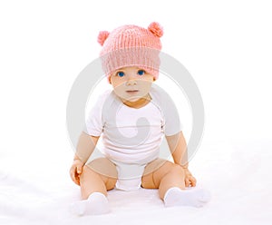 Sweet baby sitting in the pink knitted hat