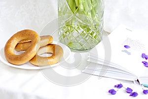 Sweet bagels and tender lupine flowers. Light composition with bright and purple flowers. A gentle and romantic morning with tea a