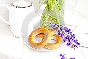 Sweet bagels and tender lupine flowers. Light composition with bright and purple flowers. A gentle and romantic morning with tea a