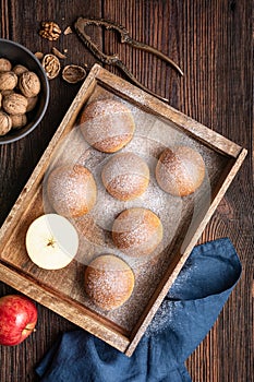 Sweet baked buns with apple and walnut filling, sprinkled with powdered sugar