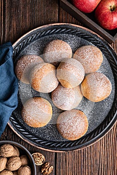 Sweet baked buns with apple and walnut filling, sprinkled with powdered sugar