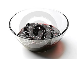 Sweet blackberry jam in the transparent glass bowl