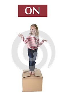 Sweet blond hair child stading on top of cardboard box isolated on white background in learning english