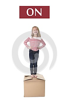 Sweet blond hair child stading on top of cardboard box isolated on white background in learning english